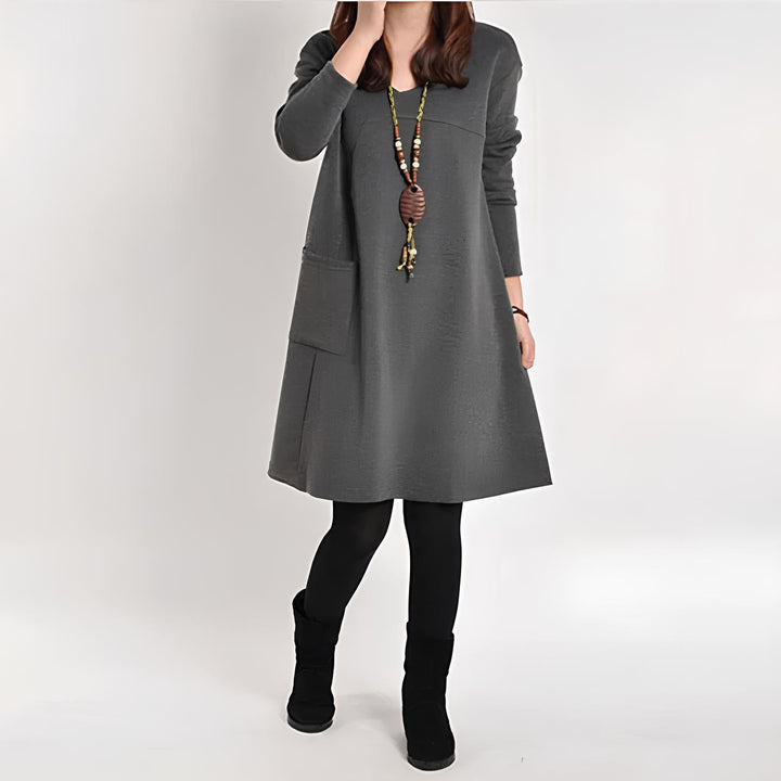 Elegante abito da donna con linea ad A, maniche lunghe, scollo rotondo e pratiche tasche frontali: una combinazione di eleganza e comfort per ogni occasione.