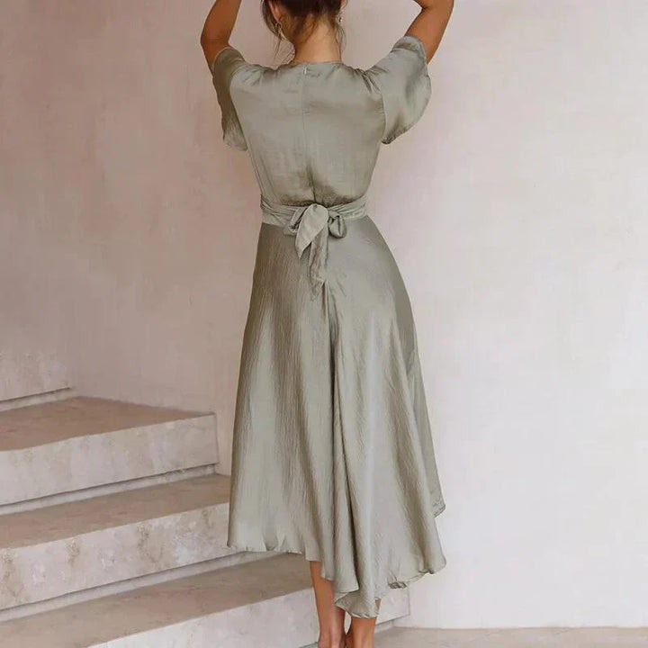 Elegante abito da donna con scollo a V, vita enfatizzata da una stecchettatura, maniche corte di grande effetto e fondo arioso con linea ad A