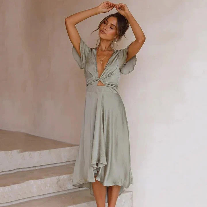Elegante abito da donna con scollo a V, vita enfatizzata da una stecchettatura, maniche corte di grande effetto e fondo arioso con linea ad A