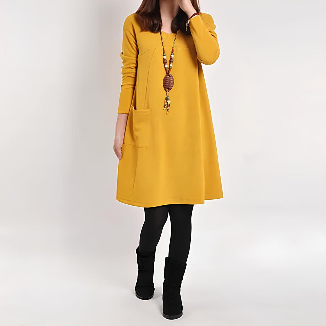 Elegante abito da donna con linea ad A, maniche lunghe, scollo rotondo e pratiche tasche frontali: una combinazione di eleganza e comfort per ogni occasione.