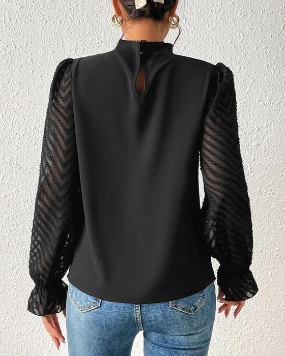 Elegante blusa femminile in chiffon con collo alto e taglio a pieghe con polsini trasparenti