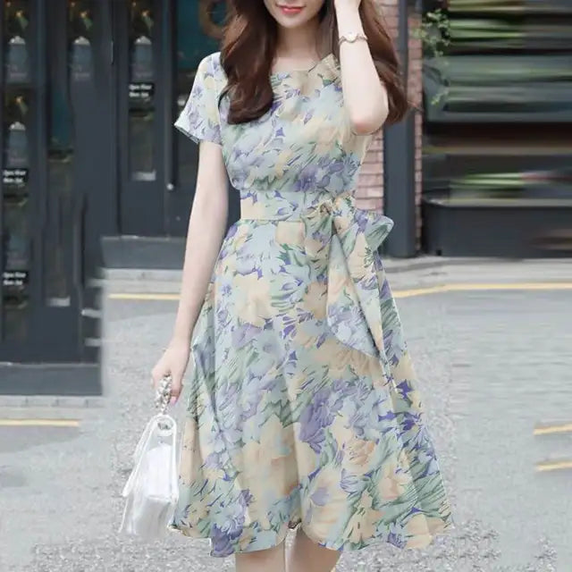 Elegante abito da donna con vestibilità e maniche a balze in stoffa leggera, con bordi in pelo, cinturino e cinturino in pelle.