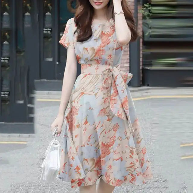 Elegante abito da donna con vestibilità e maniche a balze in stoffa leggera, con bordi in pelo, cinturino e cinturino in pelle.