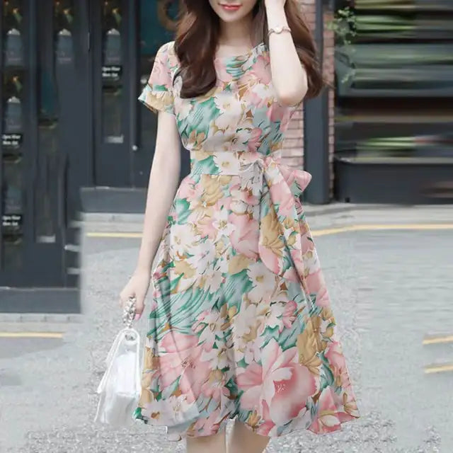 Elegante abito da donna con vestibilità e maniche a balze in stoffa leggera, con bordi in pelo, cinturino e cinturino in pelle.