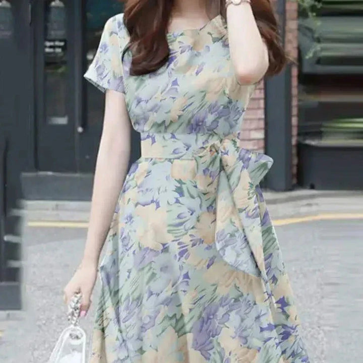 Elegante abito da donna con vestibilità e maniche a balze in stoffa leggera, con bordi in pelo, cinturino e cinturino in pelle.