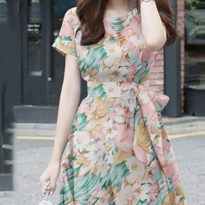 Elegante abito da donna con vestibilità e maniche a balze in stoffa leggera, con bordi in pelo, cinturino e cinturino in pelle.