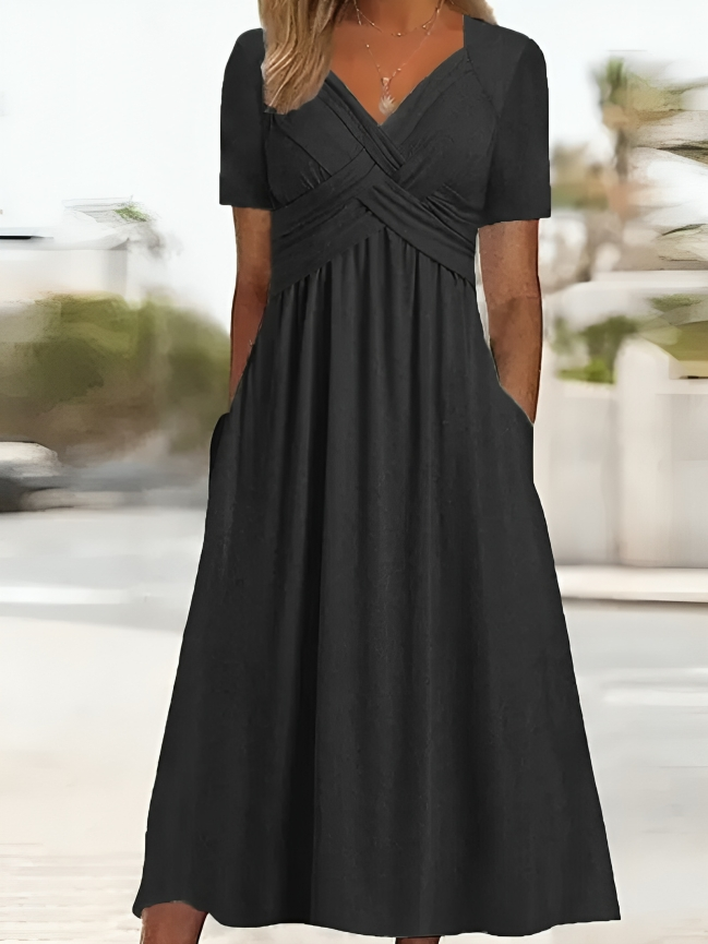 Elegante abito da donna dalla linea ad A, con vistosa scollatura incrociata, maniche corte, lunghezza al ginocchio e pratiche tasche