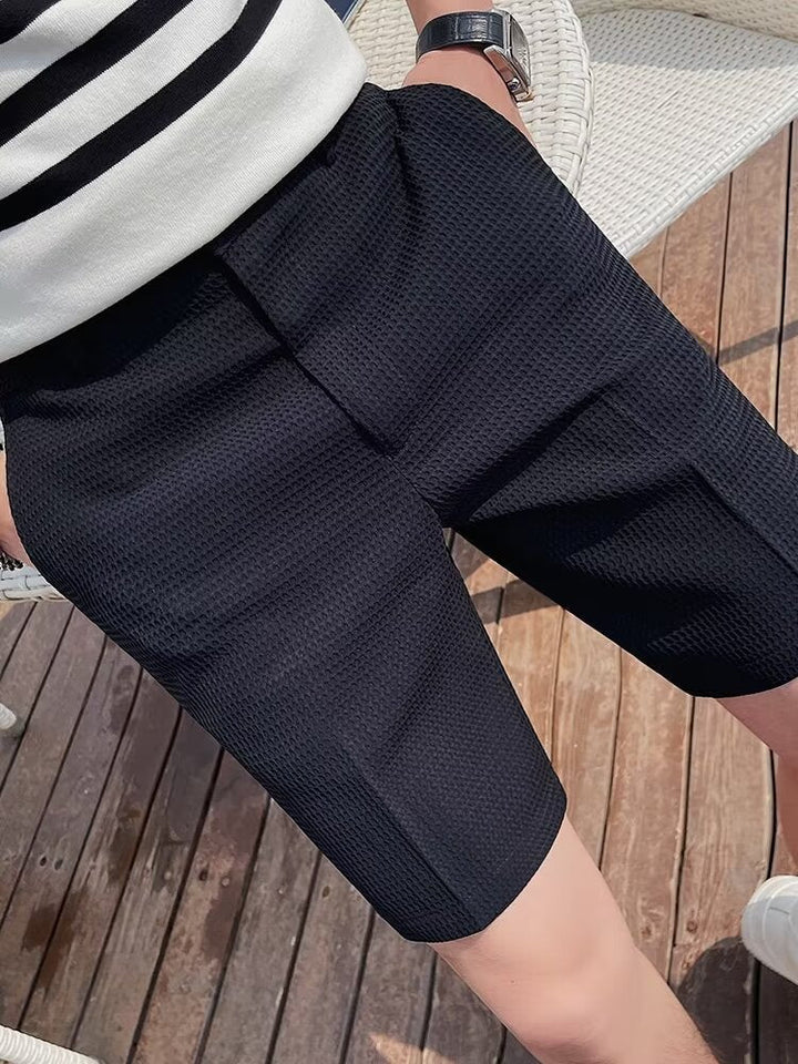 Eleganti pantaloncini da uomo slim-fit in tessuto testurizzato, con bottone, lunghezza al ginocchio e passanti per la cintura per garantire comfort ed eleganza
