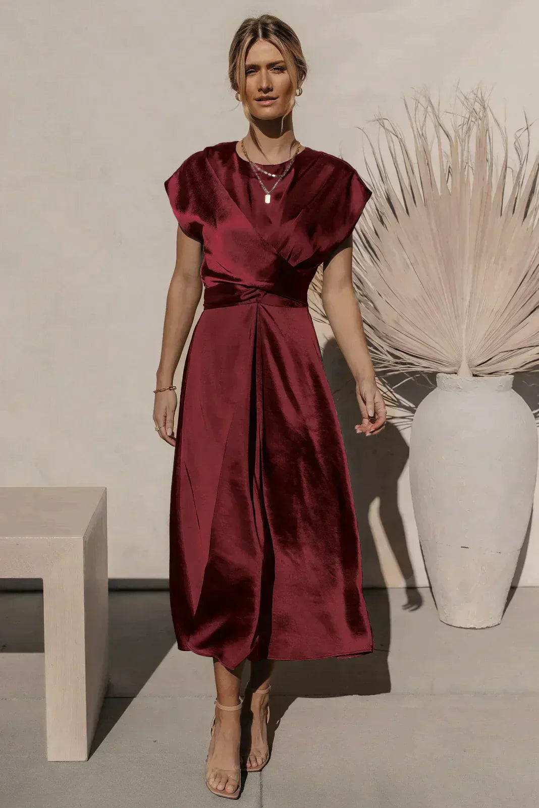 Elegante abito da sera in raso, con un drappeggio di grande effetto e una pratica cintura regolabile