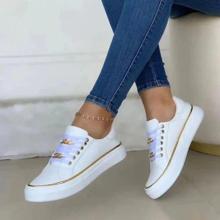 Eleganti scarpe da ginnastica da donna bianche con lussuosi accenti dorati