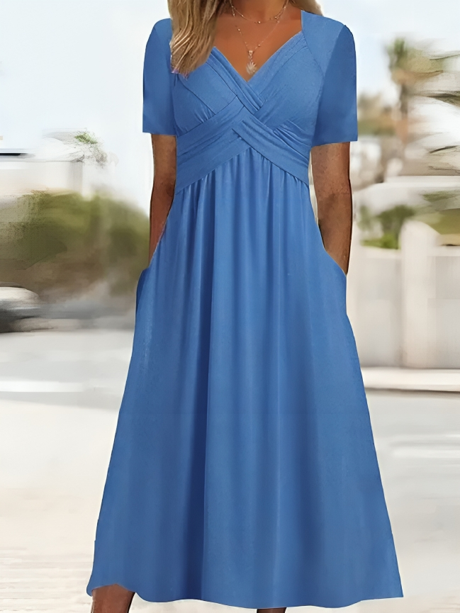 Elegante abito da donna dalla linea ad A, con vistosa scollatura incrociata, maniche corte, lunghezza al ginocchio e pratiche tasche