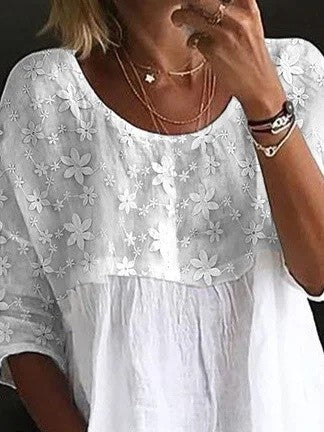 Elegante blusa da donna in cotone con vistose rientranze e applicazioni floreali, colletto classico e maniche lunghe