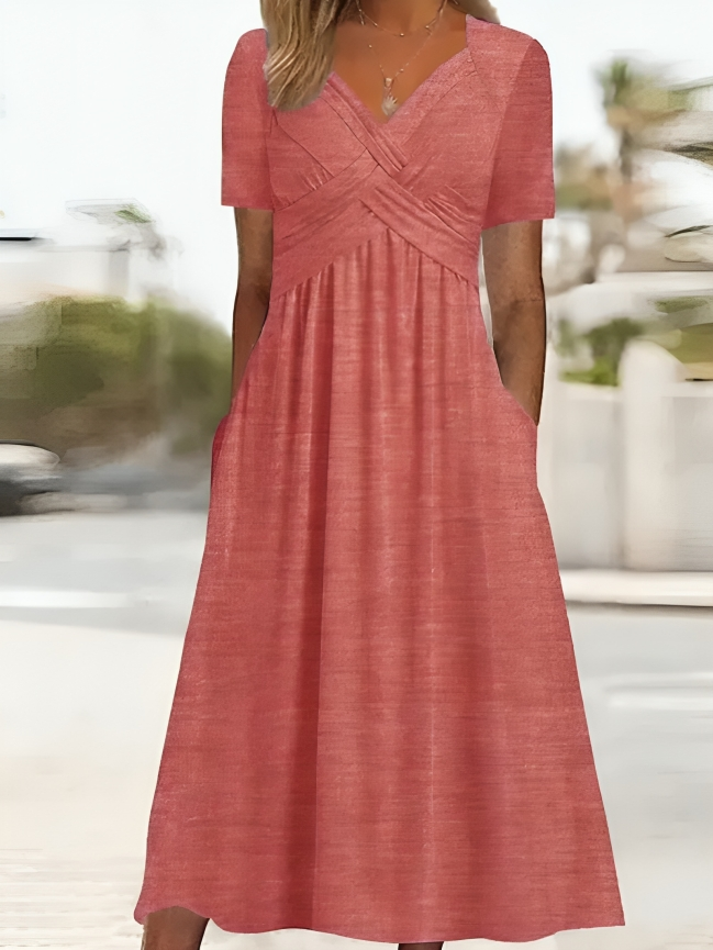Elegante abito da donna dalla linea ad A, con vistosa scollatura incrociata, maniche corte, lunghezza al ginocchio e pratiche tasche